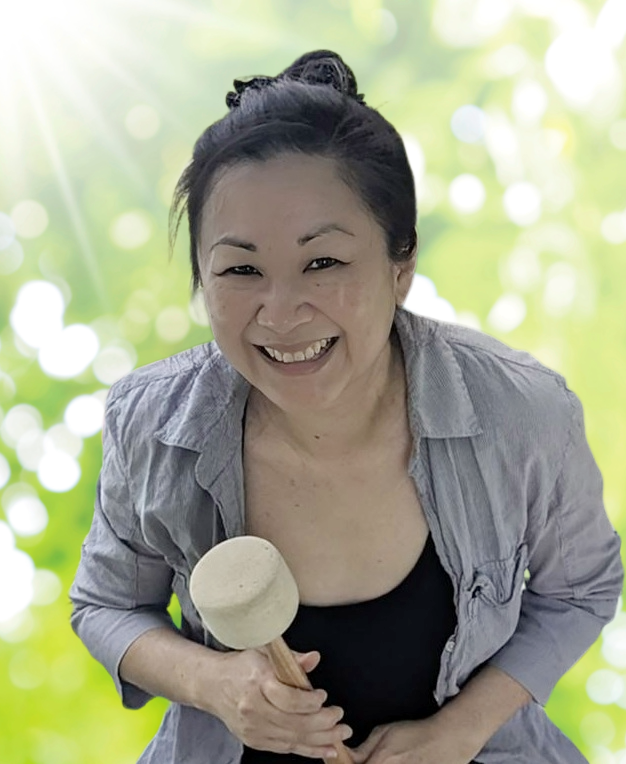 Cinsy, founder of Harmonic Glowing, performing sound meditation with singing bowls.